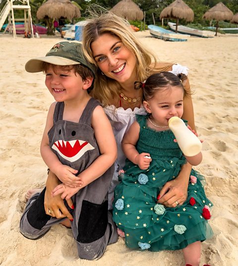 Ashley James with her children Alfie and Ada smiling on the beach