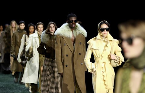 Fashion models walking down a catwalk.