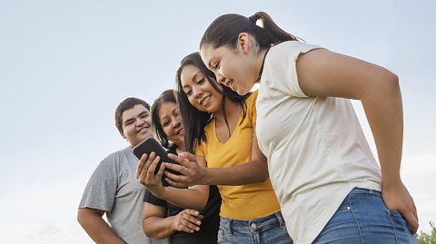 Young woman showing phone to family.