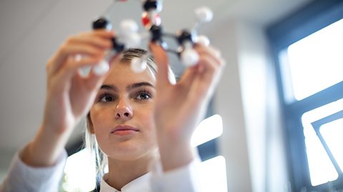 Girl pupil examining a molecular chemistry set in school