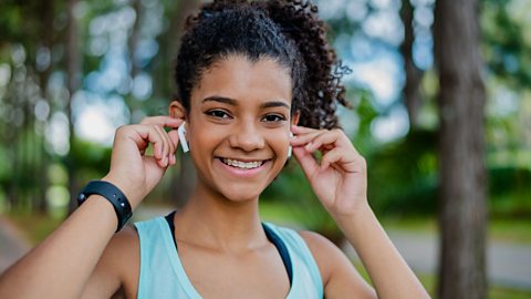 Teen in running vest with earphones in.