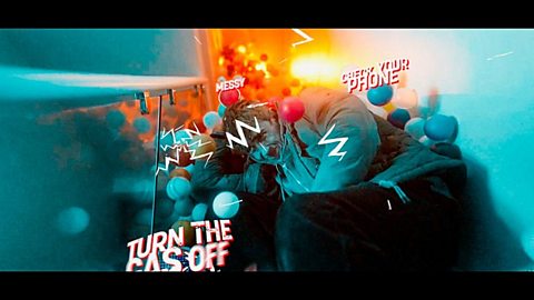 A screenshot taken from a Henry's short film. Henry is sat crouched over on the middle of a staircase. There is a flurry of plastic balls coming down the stairs, with various graphics that read 'Check your phone', 'Messy' and 'Turn the gas off' as they hit and move past Henry, who looks distressed.