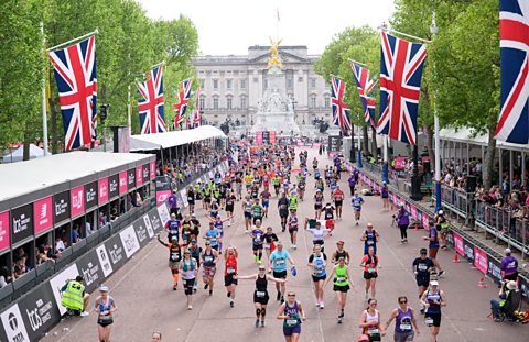Runners on the London marathon course with Buckingham Palace in the background