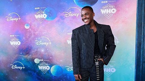 Ncuti Gatwa smiles and poses at a premiere.