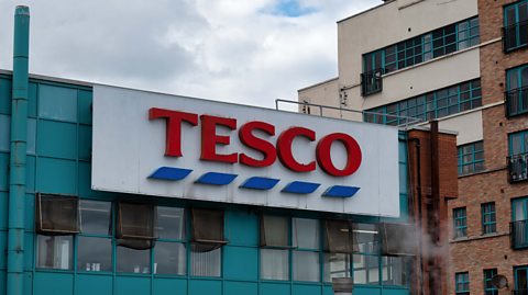 A Tesco sign on the side of a blue coloured office building in Derry/Londonderry..
