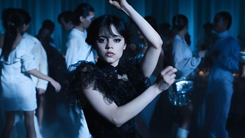 Actress Jenna Ortega as Wednesday dressed in a black tulle evening dress dances to Goo Goo Muck by The Cramps at the Nevermore Rav'N Dance