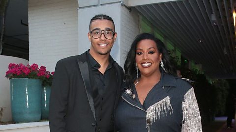 Aidan Hammond and Mum Alison Hammond posing outside a house with red roses in the background