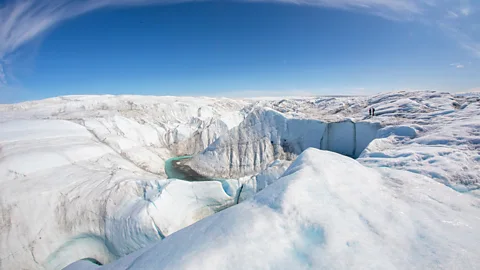 Stuart Butler vast expanse of Greenland's ice sheet with deep crevasses and sharp ridges under a pale blue sky (Credit: Stuart Butler)