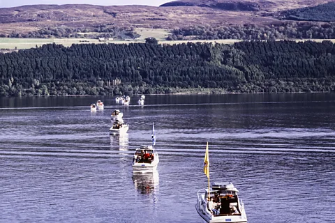 Getty Images Boats on Loch Ness with the Scottish countryside in the distance (Credit: Getty Images)