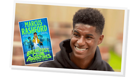 A man smiling, wearing a black hoodie with a small image of a book called Breakfast club Adventures