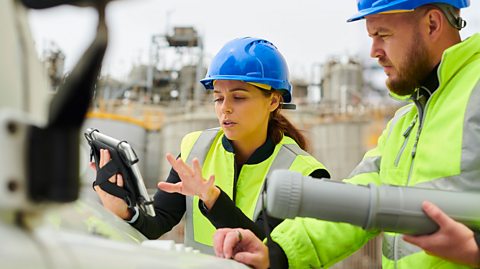 Two people in hi-vis jackets and hard hats.