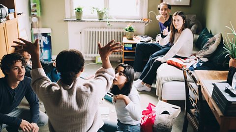 Friends at sleepover look at girl in front 