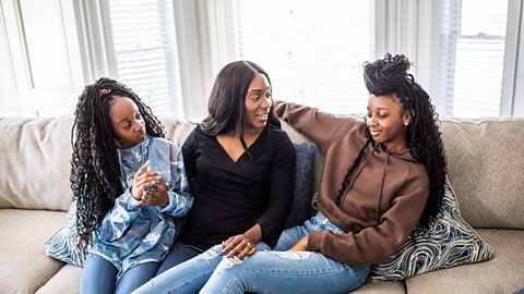 Mum on couch talking to her daughters 