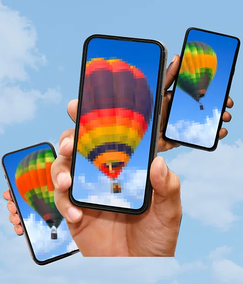 Serenity Strull/ Getty Images Hands holding three smartphones with different levels of pixelations of a hot air balloon in the sky (Credit: Serenity Strull/ Getty Images)