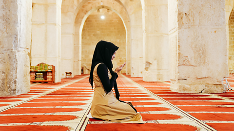 Woman praying in a mosque in Saudia Arabia.