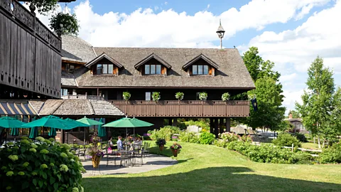 Chadwick Estey Von Trapp Family Lodge & Resort with people sitting on green umbrellas outside next to neat lawn (Credit: Chadwick Estey)