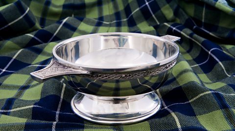 A quaich dish on top of tartan material