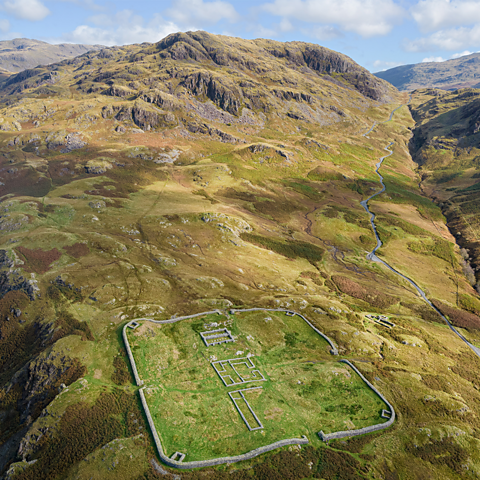 The stone remains of Hardknott Fort with the Eskdale mountains in the background.