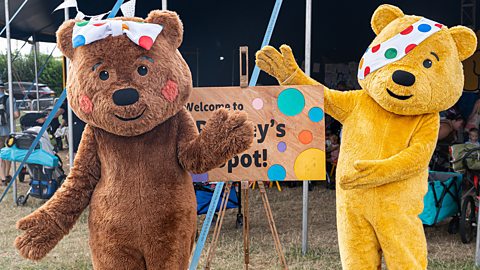 Blush Bear, brown with a spotted bow, with Pudsey Bear, yellow with a spotted bandana
