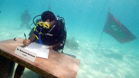 Alamy The former president of the Maldives signs a document in scuba gear, underwater (Credit: Alamy)