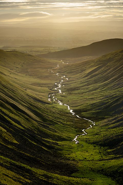A river in a valley in low light