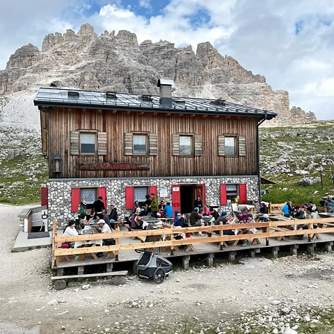 Mike MacEacheran Refugio Lavaredo's long wooden tables fill with hikers stopping for food, beer and a break on the Tre Cime trail (Credit: Mike MacEacheran)