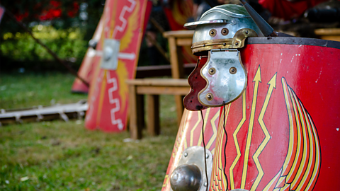 A photograph of a Roman helmet and shield from a re-enactment.