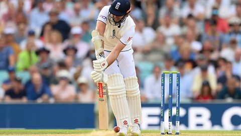 James Anderson, batting left handed, successfully blocks a yorker in front of his wickets. He is wearing his England whites, denoting that it's a Test match