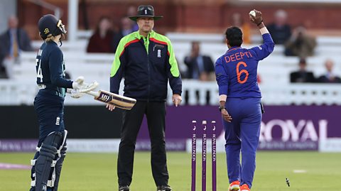 Indian bowler Deepti Sharma holds the ball aloft and appeals to the umpire after running out England's Charlie Dean at the non-striker's end. The bails are flying off and Dean is looking towards the umpire and Sharma with her arms and bat wide.