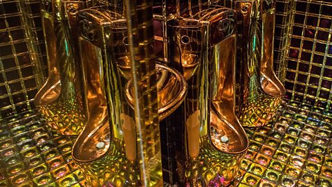 Golden urinals with reflective mosaic tiles at Shinjuku Robot Restaurant in Tokyo, showcasing futuristic bathroom design