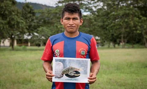 Karen Toro Germán Narankas, a member of the Shuar community, with one of the species he and his community discovered (Credit: Karen Toro)