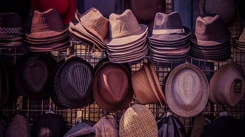 Multiple mens' hats hanging on wire racks ready for sale
