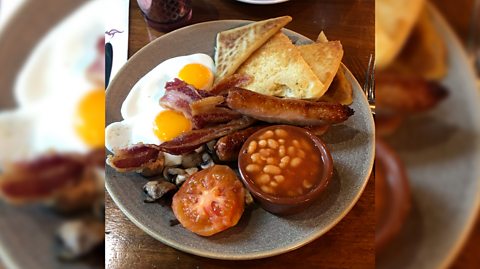 An Ulster fry breakfast - a traditional Northern Irish breakfast, with eggs, bacon, sausage, mushrooms, tomato, beans and potato bread 