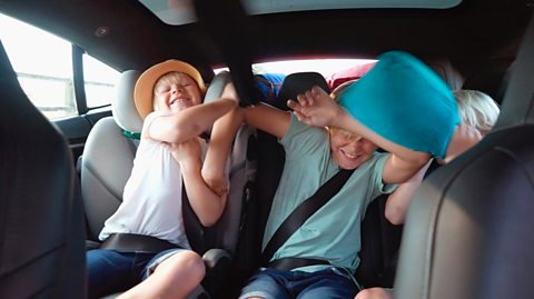 kids play fight in a car