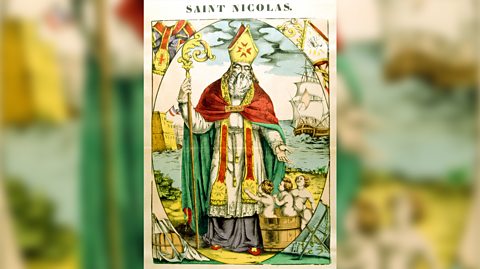 An illustration of Saint Nicholas, who holds a gold sceptre and wears a red and green cloak and a gold and red mitre hat. Behind him is a ship on the water. He gestures down to three young boys he saved, who are standing in a wooden basket