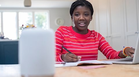 Teenage Girl Doing Homework At Home Asking Digital Assistant Question 
