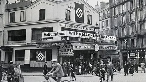 Nazi flags and German signs festoon the cafe across from the Moulin Rouge, in 1940. The cafe was reserved for exclusive use by German soldiers
