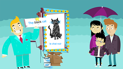 Burt standing in front of his display with 'le chat noir' on it. He's holding a sign with the black cat written on it.