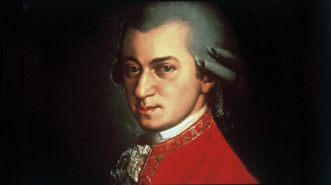 A painting of famous Austrian composer Wolfgang Amadeus Mozart. He wears a distinctive red coat with gold brocade trimming and a powdered wig, typically worn in the 18th century