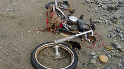 Rusty motorbike on the sand.