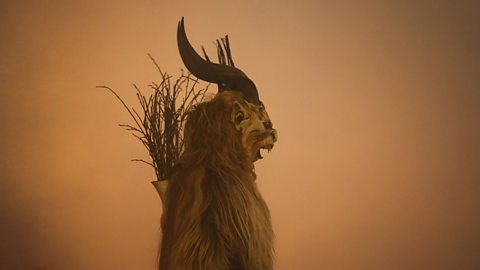 The horned figure of Krampus stands alone, with a backdrop of orange smoke