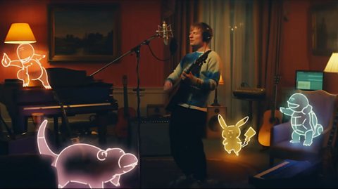 Ed Sheeran surrounded by the Pokémon Charmander, Pikachu, Squirtle and Slowpoke.