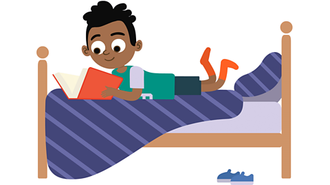 a boy lying on his bed reading