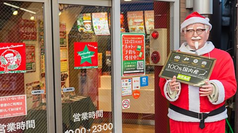 KFC's fried chicken is popular at Christmas in Japan. Col Saunders statue dressed in a Santa suit outside a Japanese KFC restuarant