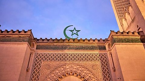The Grande Mosquee de Paris Ahead of Ramadan. The photograph shows part of the mosque lit up in the foreground, with a darker blue sky background.