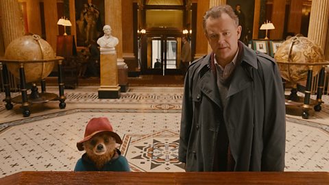 Paddington Bear, wearing trademark duffel coat and red hat, stood next to Hugh Bonneville's Mr Brown