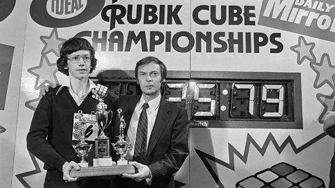 15 year-old Julian Chilvers holding his three trophies with inventor and architect professor Erno Rubik after winning the Rubik Cube Championships