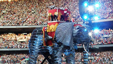 The 2009 version of Take That - Gary Barlow, Jason Orange, Howard Donald and Mark Owen - riding upon a mechanical elephant with three tiers of Wembley fans behind them
