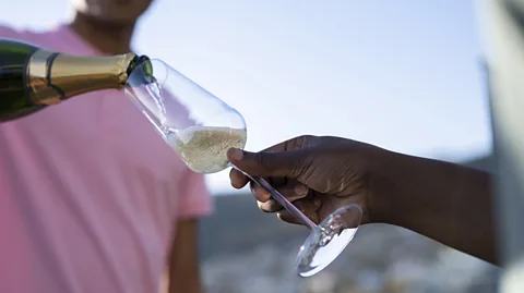 Getty Images A sideways tilt helps retain more fizz than pouring into a glass held vertically (Credit: Getty Images)