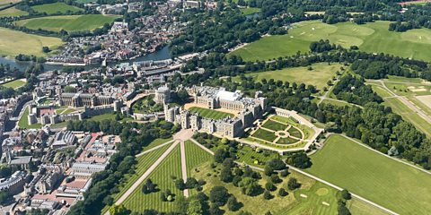 An aerial view of Windsor Castle in the centre and the surrounding area of green land and acres, as well as homes